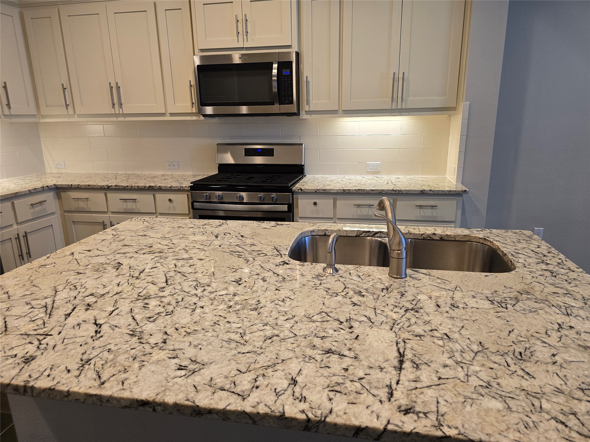 13800 Lyndhurst Street, Unit 233 Austin, TX 78717 - Photo 8 of 38 a kitchen with a sink a stove and microwave