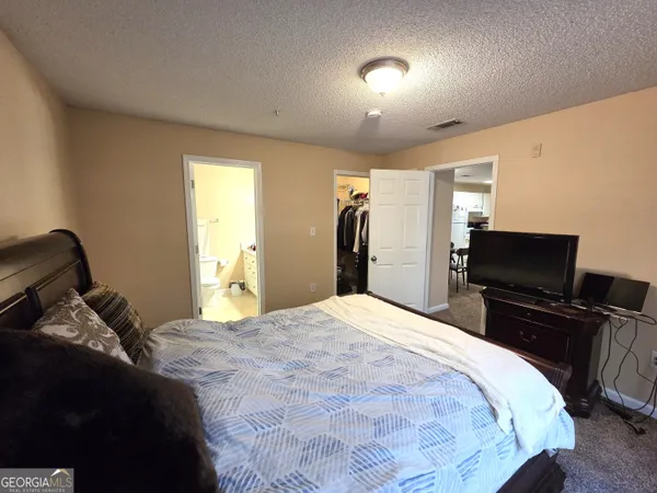a bedroom with a bed and a flat screen tv