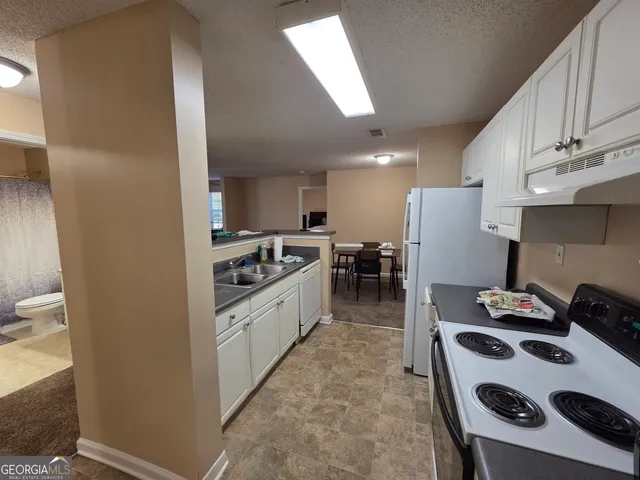 a kitchen with a refrigerator a stove and a sink