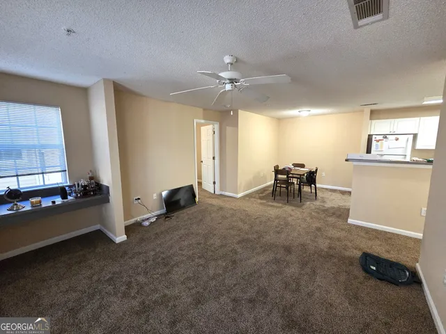 a view of a livingroom with furniture and a ceiling fan