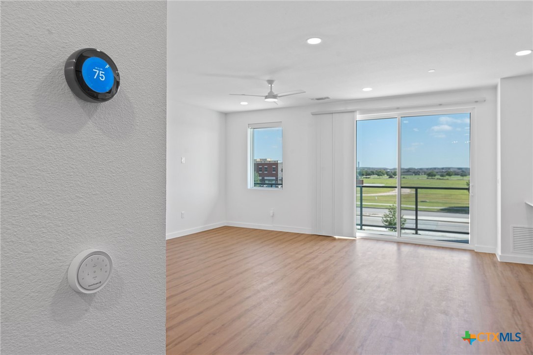 2165 Gabriels Place, Unit 1203 New Braunfels, TX 78130 - Photo 12 of 38 an empty room with wooden floor and windows