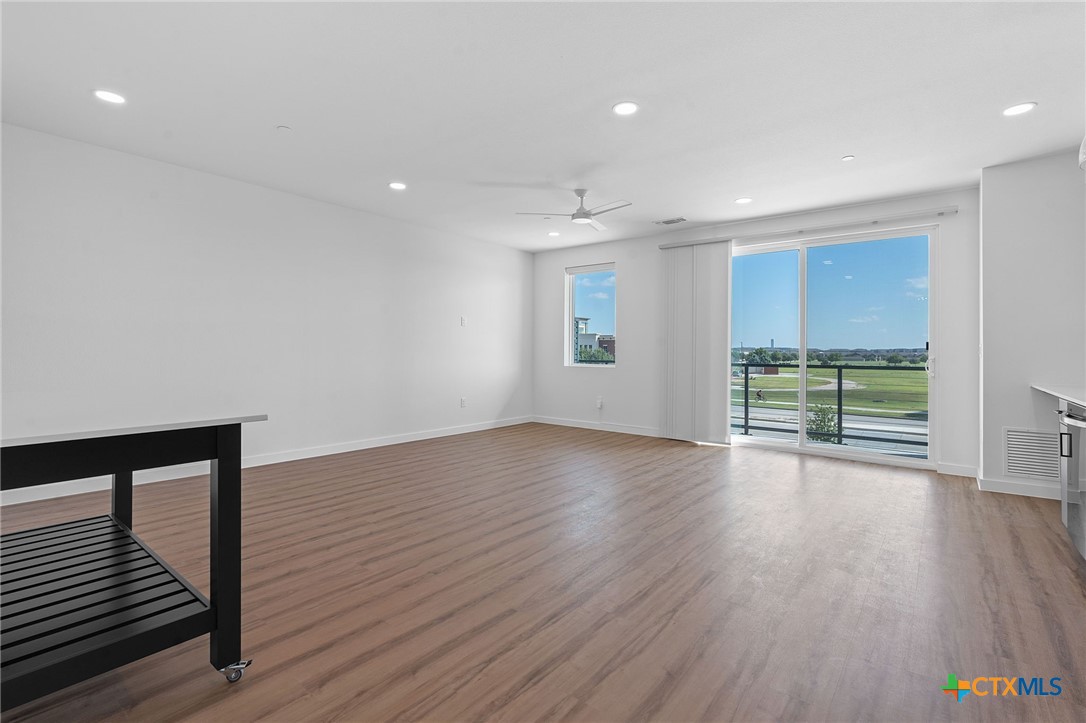 2165 Gabriels Place, Unit 1203 New Braunfels, TX 78130 - Photo 13 of 38 a view of an empty room with wooden floor and a window