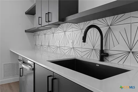 a kitchen with stainless steel appliances a sink a stove and cabinets