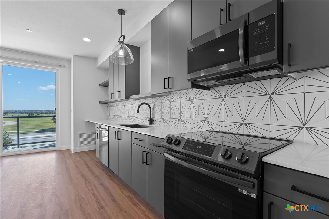 2165 Gabriels Place, Unit 1203 New Braunfels, TX 78130 - Photo 10 of 38 a kitchen with stainless steel appliances a sink a stove and cabinets