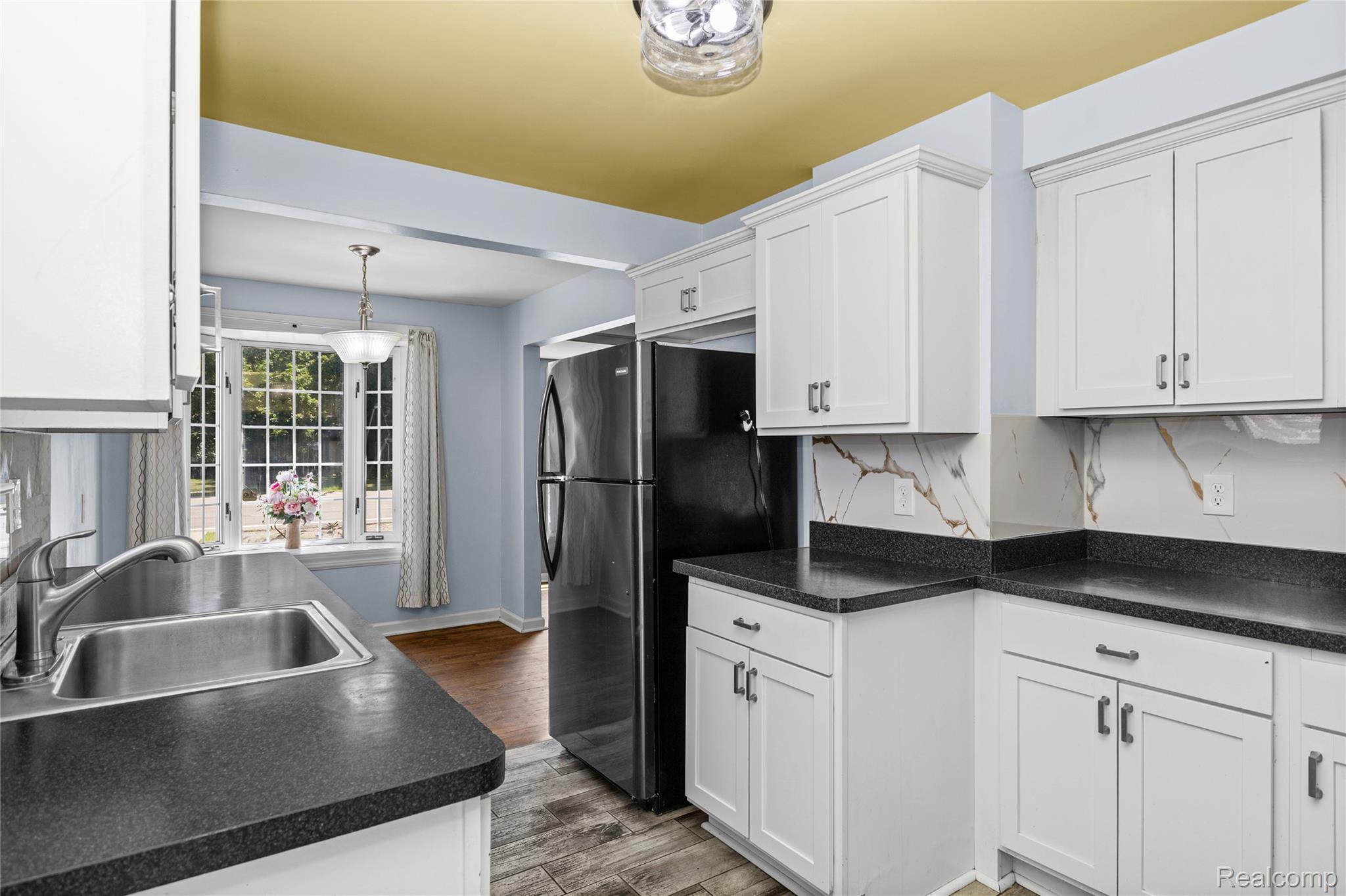 26508 Five Mile Road Redford, MI 48239 - Photo 20 of 41 Kitchen featuring white shaker-style cabinetry, dark speckled countertops, and a white and brown veined backsplash