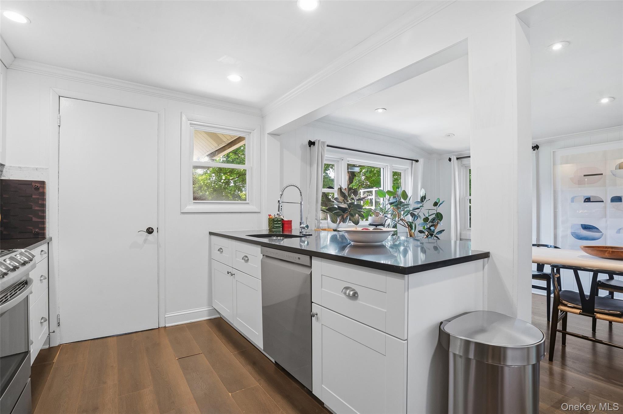 36 Dearborn Avenue Rye, NY 10580 - Photo 12 of 30 a kitchen with granite countertop a sink and white cabinets with wooden floor