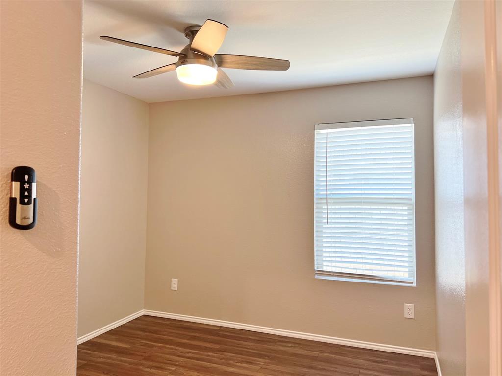 1103 Wildflower Street Ennis, TX 75119 - Photo 11 of 15 an empty room with a window and a ceiling fan