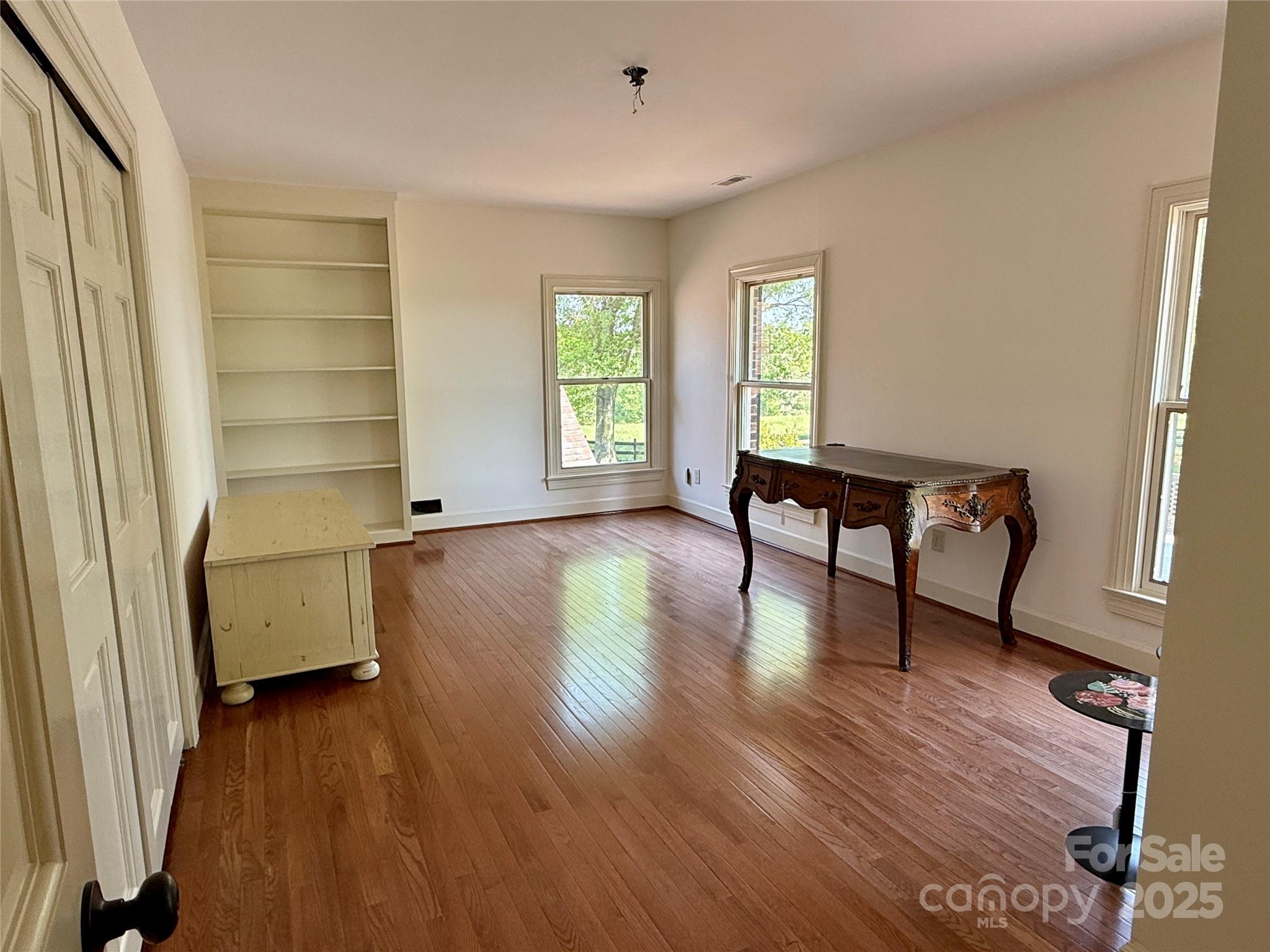 820 Phillips Road Columbus, NC 28722 - Photo 27 of 32 an empty room with wooden floor and windows