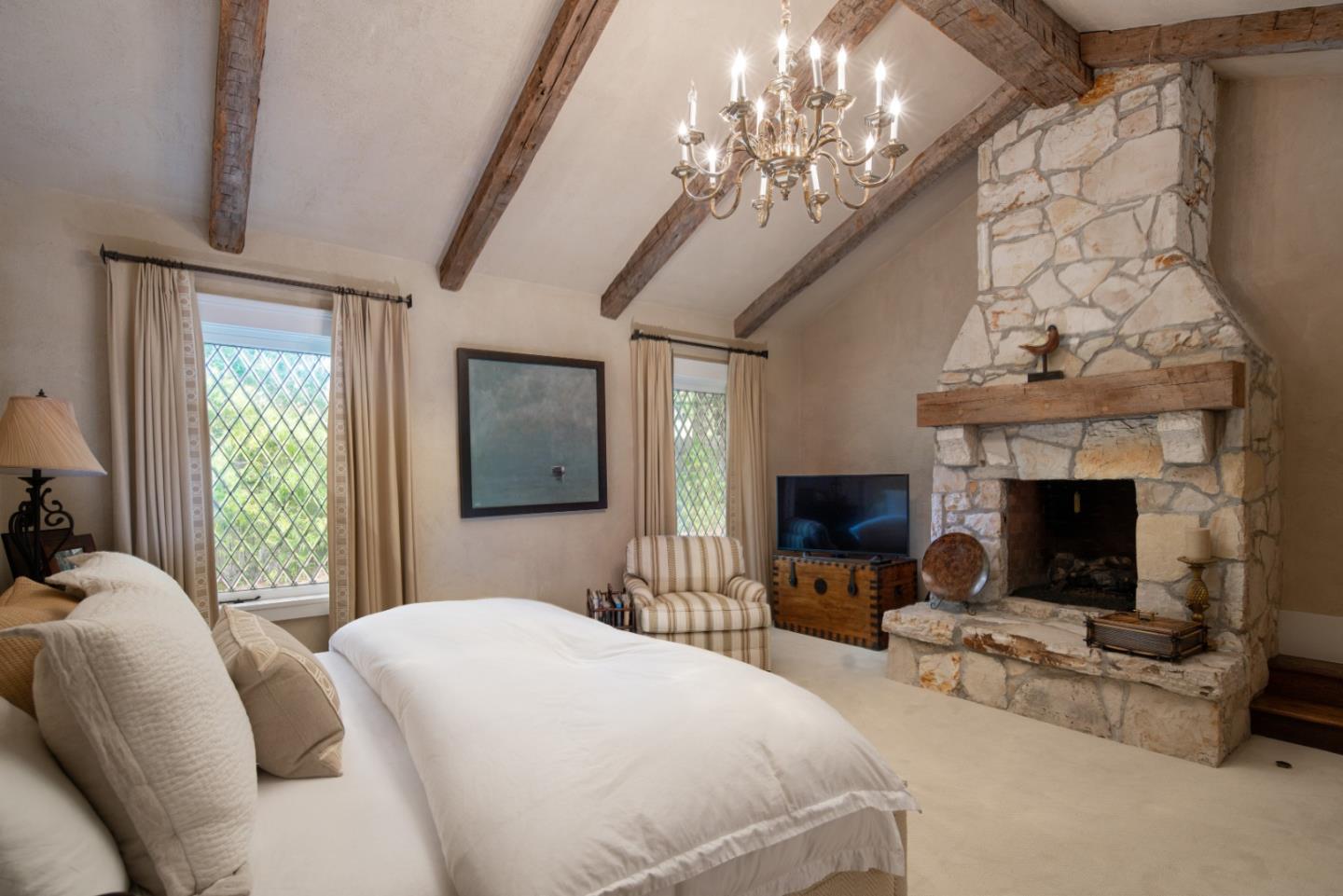 1456 Riata Road Pebble Beach, CA 93953 - Photo 14 of 32 a bedroom with a large bed and a fireplace