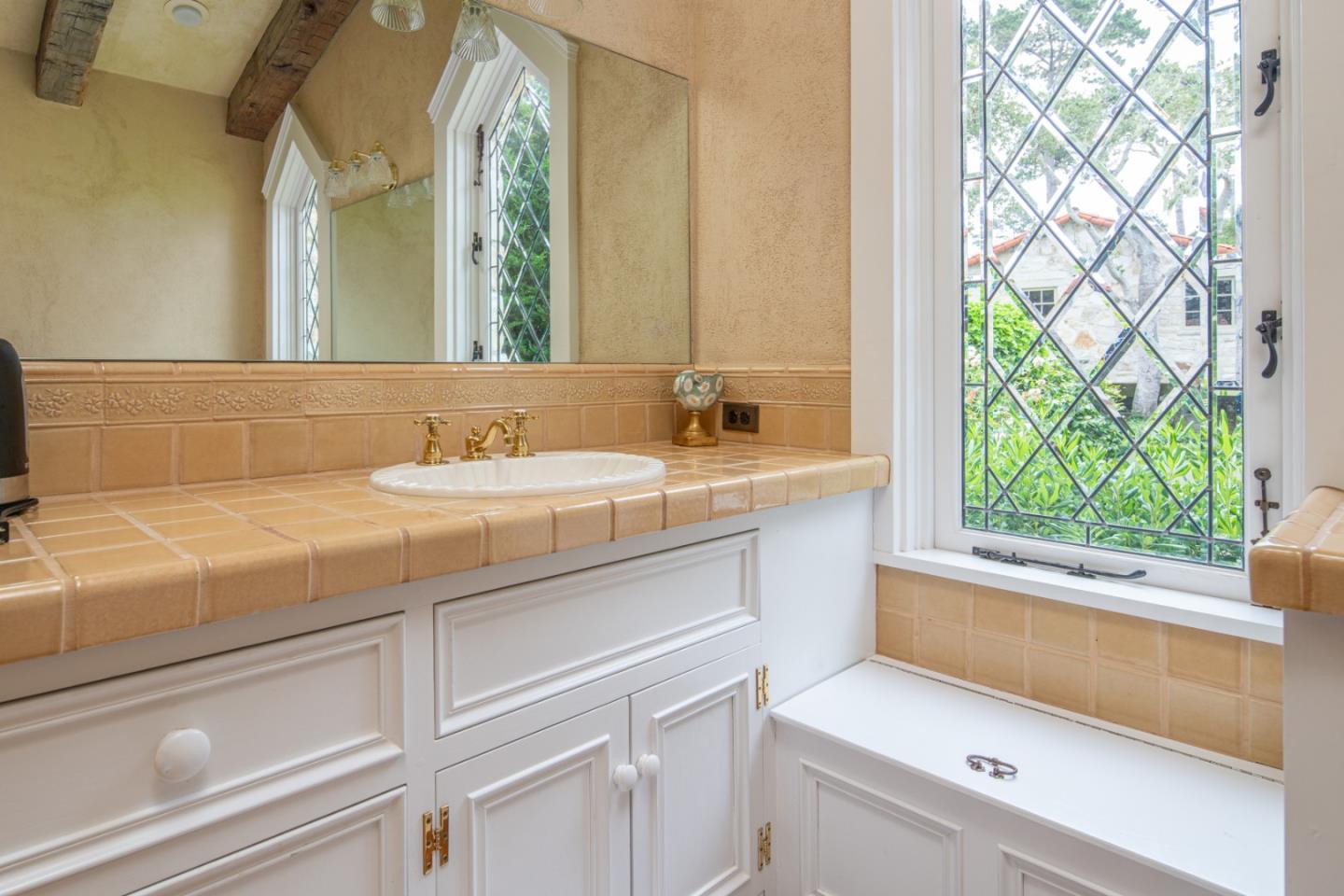 1456 Riata Road Pebble Beach, CA 93953 - Photo 16 of 32 a bathroom with a sink and a mirror next to a window