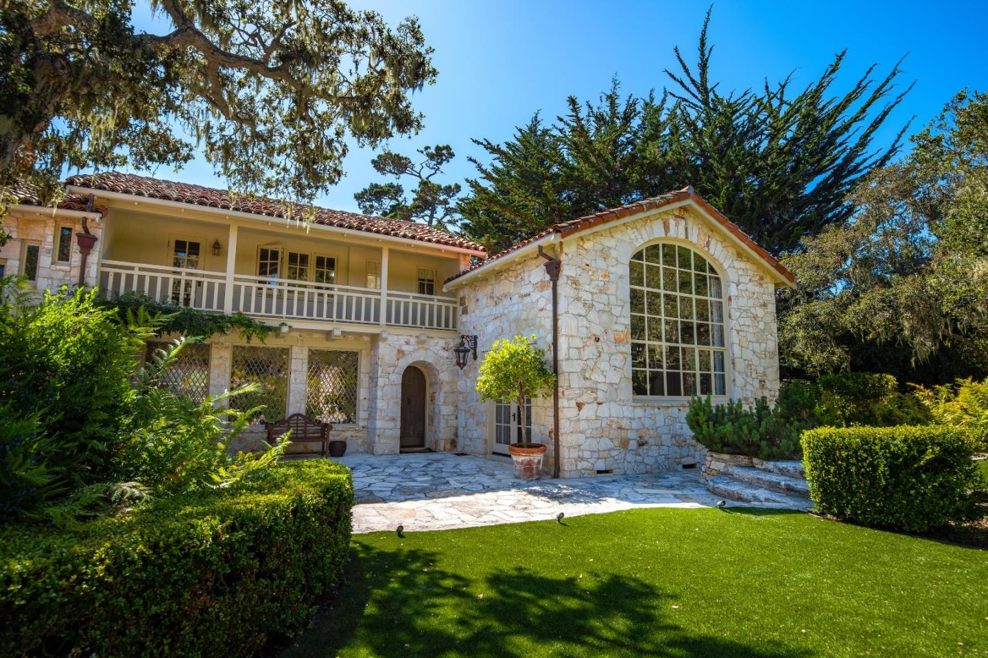 1456 Riata Road Pebble Beach, CA 93953 - Photo 2 of 32 a front view of a house with a yard and potted plants