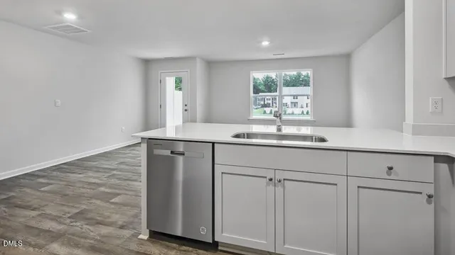 a view of an empty room with wooden floor and closet