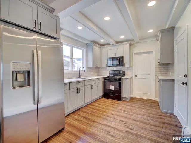 a kitchen with granite countertop a refrigerator stove top oven and sink