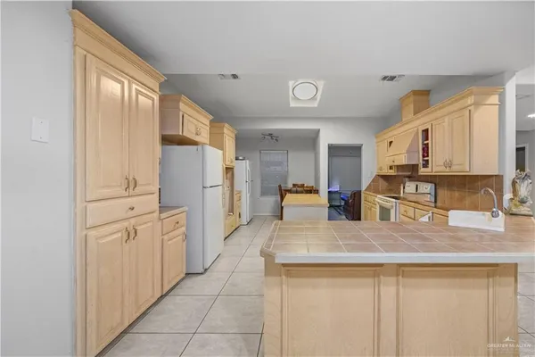 a kitchen with stainless steel appliances granite countertop a refrigerator and a stove