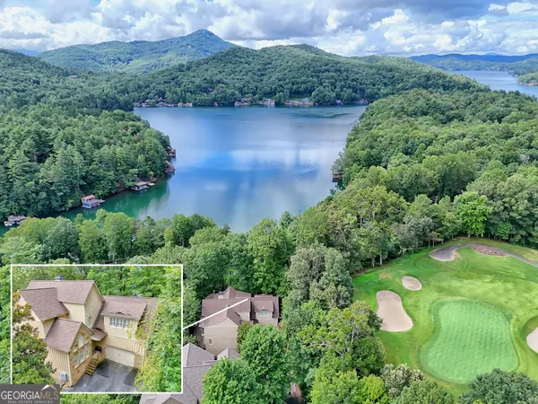 an aerial view of a house with garden space and a lake view