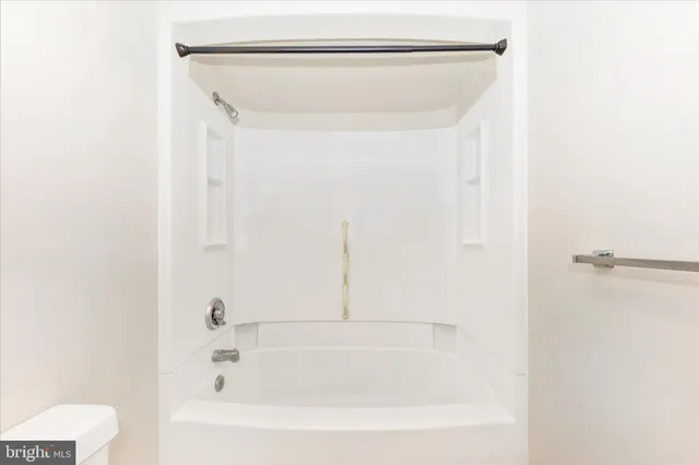 a big room with chandelier fan and windows