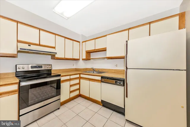 a kitchen with stainless steel appliances granite countertop a refrigerator sink stove and cabinets