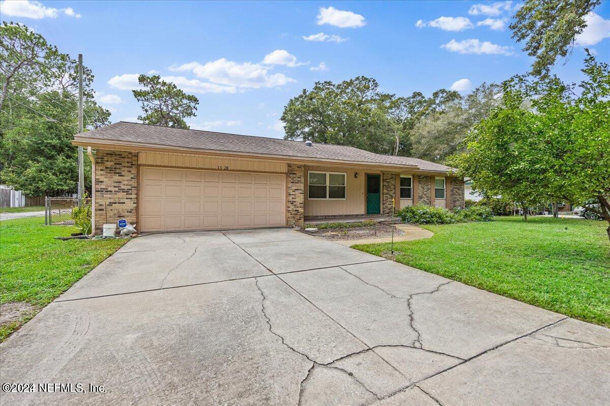 a front view of a house with a yard and potted plants