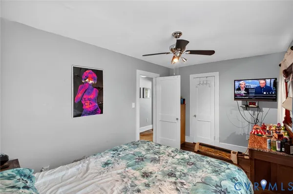 a bedroom with furniture fan and a chandelier fan