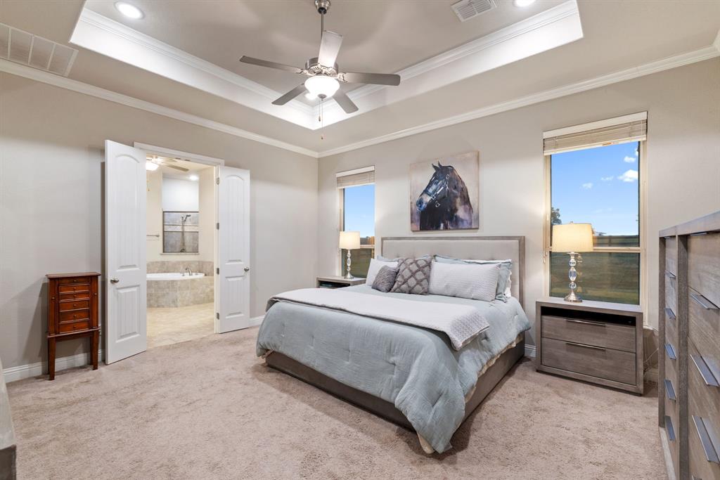 251 Hlavek Road Decatur, TX 76234 - Photo 19 of 33 a spacious bedroom with a bed and a chandelier