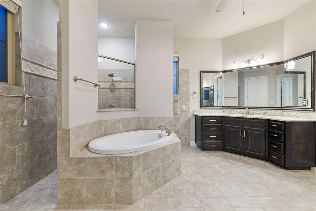 251 Hlavek Road Decatur, TX 76234 - Photo 22 of 33 a bathroom with a tub sink double vanity and a mirror
