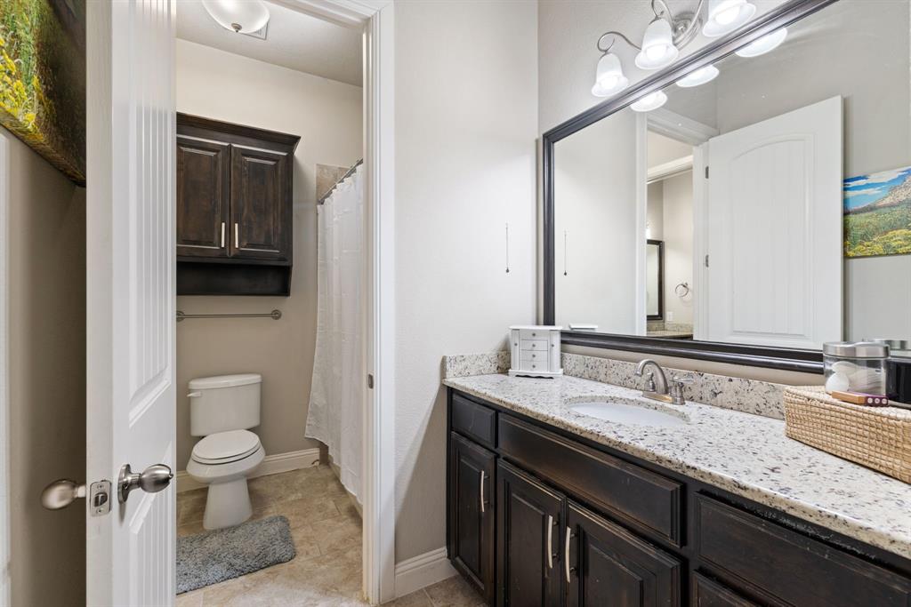 251 Hlavek Road Decatur, TX 76234 - Photo 26 of 33 a bathroom with a granite countertop sink a toilet and a mirror