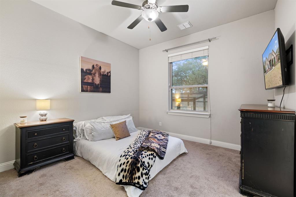 251 Hlavek Road Decatur, TX 76234 - Photo 27 of 33 a bedroom with a bed and a flat tv screen on dresser