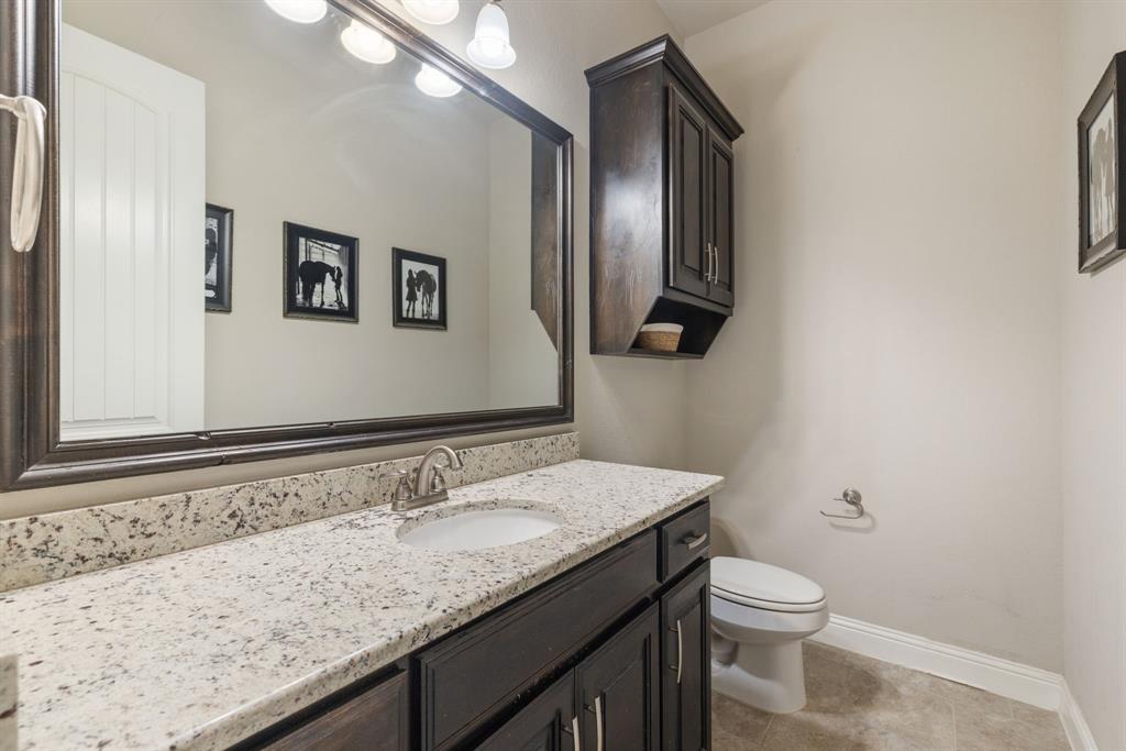 251 Hlavek Road Decatur, TX 76234 - Photo 32 of 33 a bathroom with a granite countertop sink a toilet and a mirror