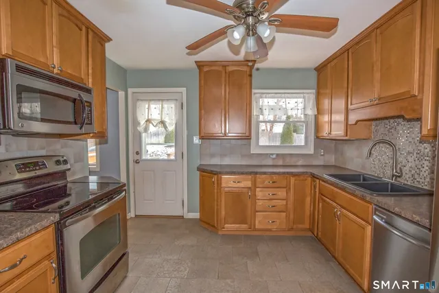 a kitchen with stainless steel appliances granite countertop a sink stove and microwave