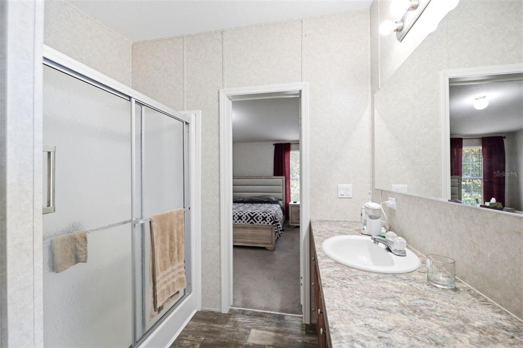 3183 Cedley Road Dade City, FL 33523 - Photo 15 of 48 a en suite bathroom with a granite countertop sink and a mirror