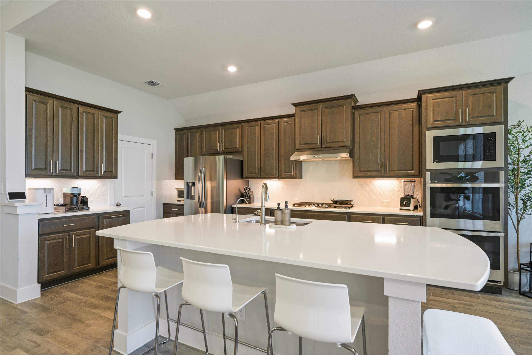238 Wild Pecan Loop Buda, TX 78610 - Photo 9 of 31 Ample cabinetry and a large central island anchor this modern, light-filled kitchen space.