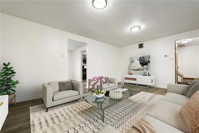 a view of an empty room with wooden floor and cabinets