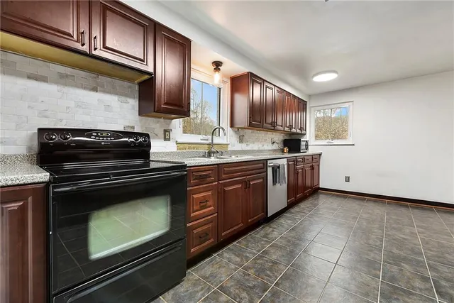 a kitchen with stainless steel appliances granite countertop a sink stove and cabinets