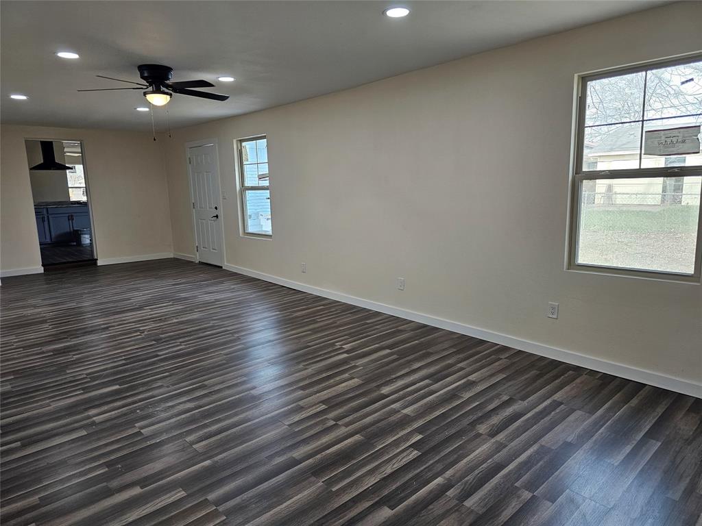 4317 Gram Lane Bellmead, TX 76705 - Photo 12 of 34 an empty room with wooden floor chandelier fan and windows