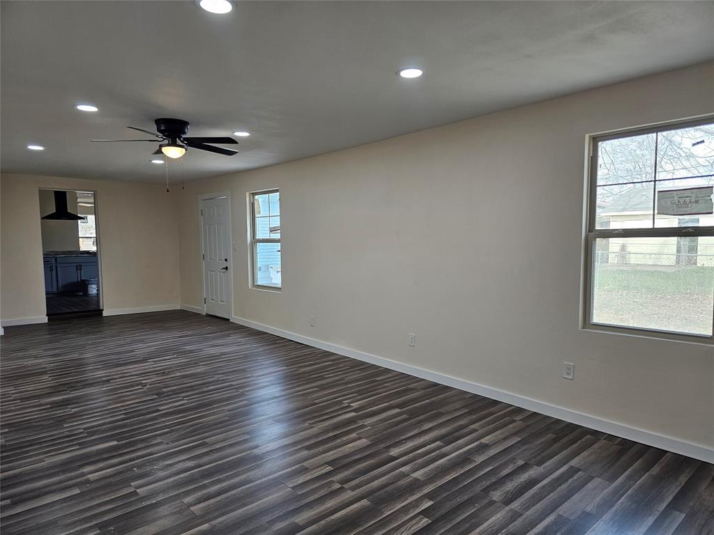 4317 Gram Lane Bellmead, TX 76705 - Photo 8 of 34 an empty room with wooden floor chandelier fan and windows