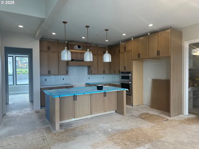 a large kitchen with stainless steel appliances kitchen island granite countertop a sink and cabinets