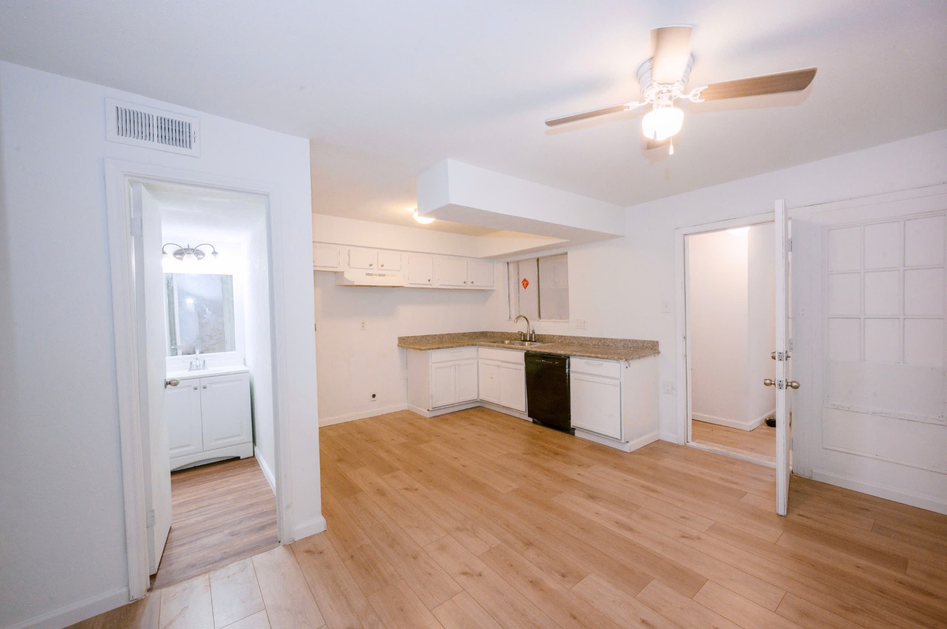 12048 Beechnut Street Houston, TX 77072 - Photo 2 of 21 a view of kitchen and empty room with wooden floor