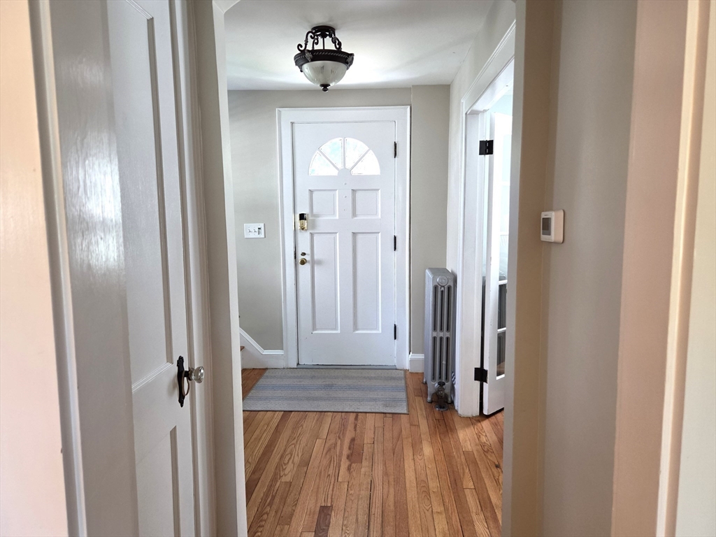 25 Waldeck Road Milton, MA 02186 - Photo 17 of 34 a view of a hallway with wooden floor and a livingroom