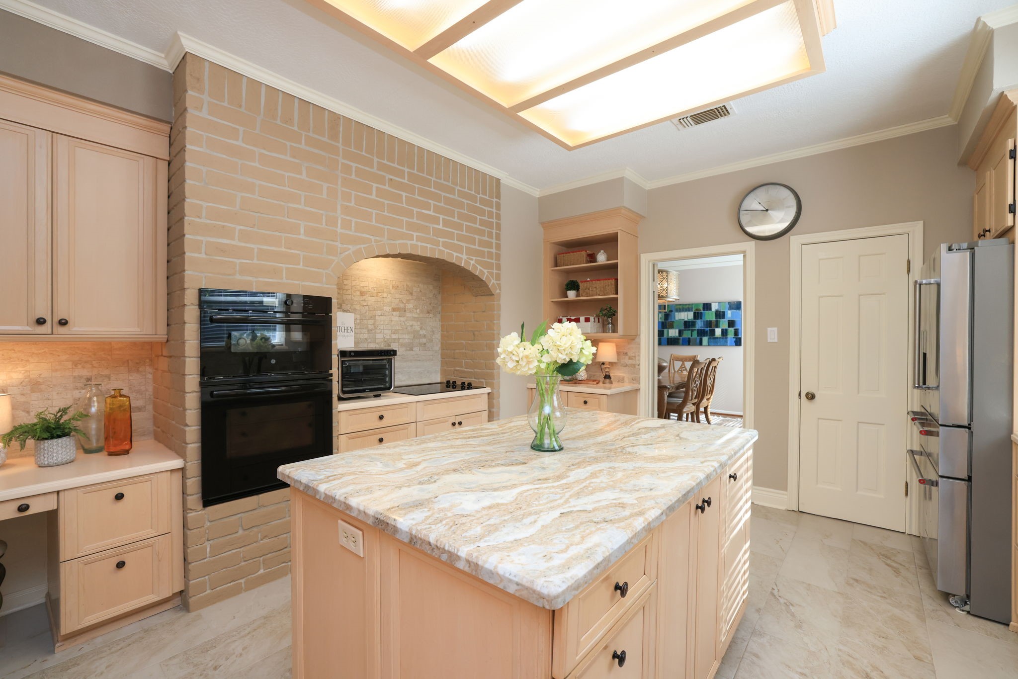 16123 Chasemore Drive Spring, TX 77379 - Photo 19 of 50 This view of the kitchen shows the stunning brick wall with oven & microwave plus inset glass stove top. A built in desk is shown to the left of the oven.