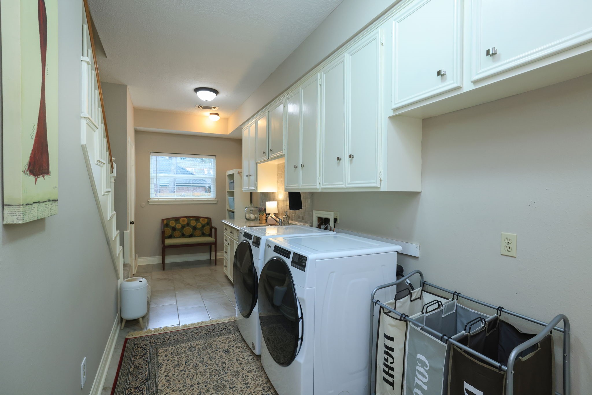 16123 Chasemore Drive Spring, TX 77379 - Photo 22 of 50 This photo features a well-lit, organized laundry room with ample white cabinetry for plenty of storage.