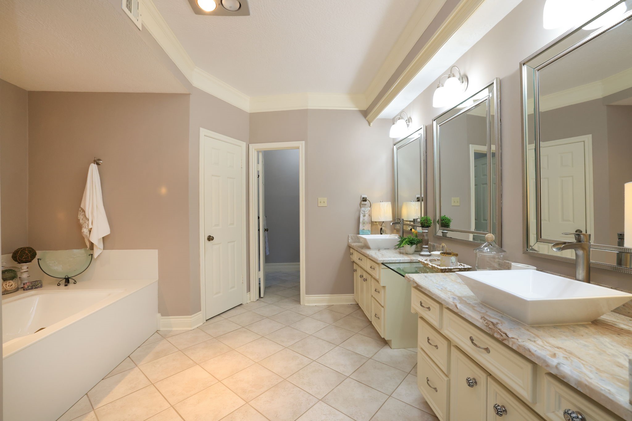 16123 Chasemore Drive Spring, TX 77379 - Photo 24 of 50 This spacious primary bathroom features a double vanity with modern vessel sinks, large mirrors, and whirlpool tub.