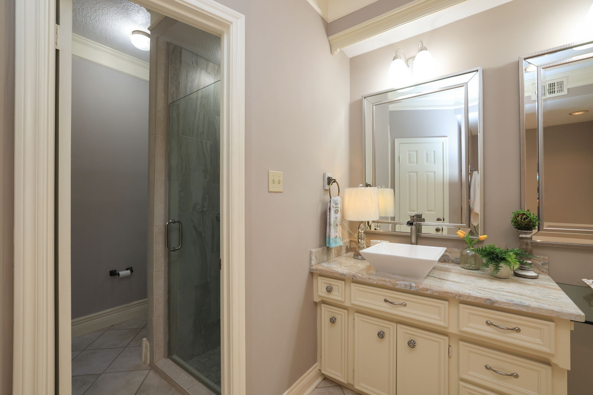 16123 Chasemore Drive Spring, TX 77379 - Photo 25 of 50 This modern bathroom features a remodeled glass-enclosed shower, a stylish vanity with a vessel sink, and elegant lighting.