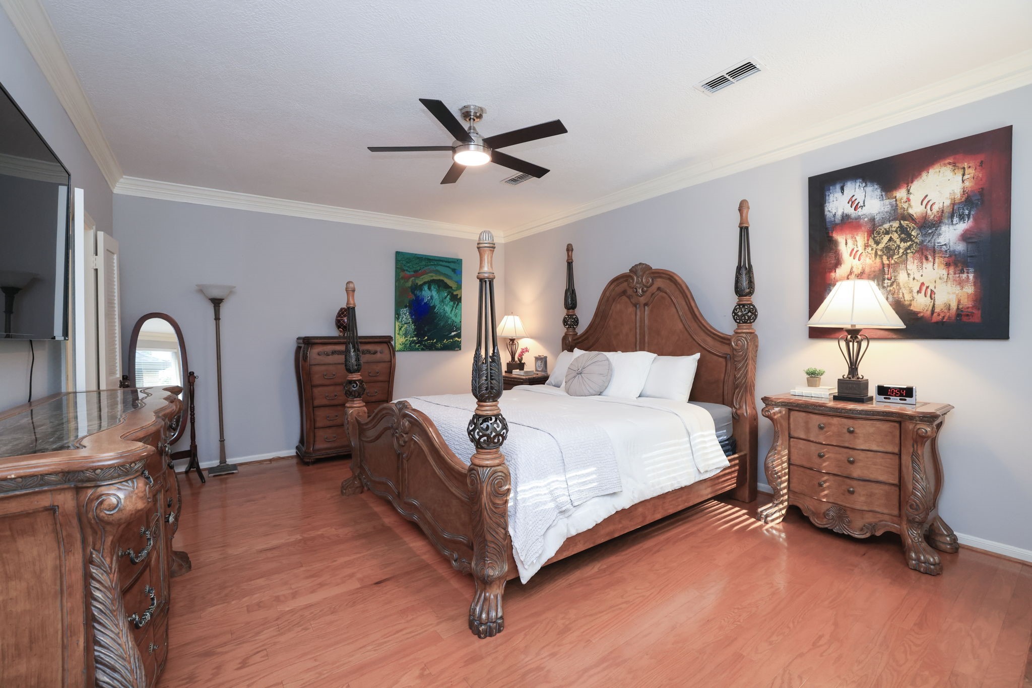 16123 Chasemore Drive Spring, TX 77379 - Photo 26 of 50 The spacious primary bedroom bedroom features warm hardwood floors, modern ceiling fan, creating a cozy and inviting atmosphere.