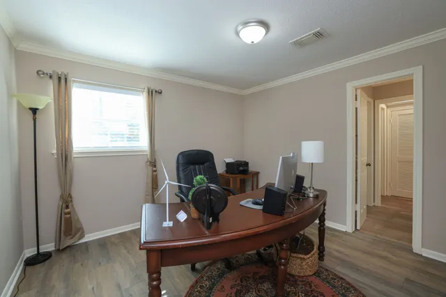 a view of a workspace with furniture and wooden floor