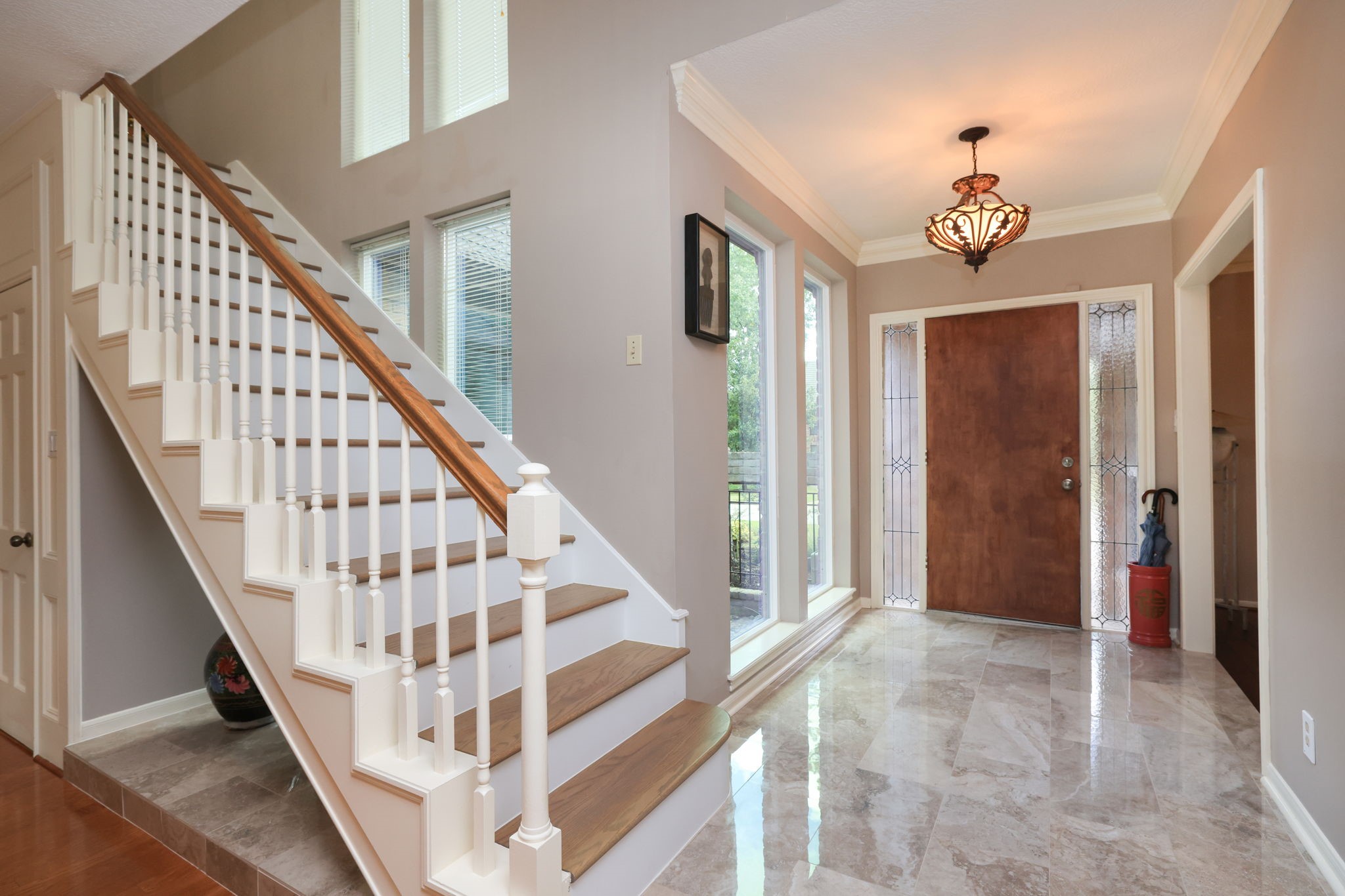 16123 Chasemore Drive Spring, TX 77379 - Photo 4 of 50 This entryway has a solid wooden front door, elegant tile flooring, and a classic staircase with wood stairs.