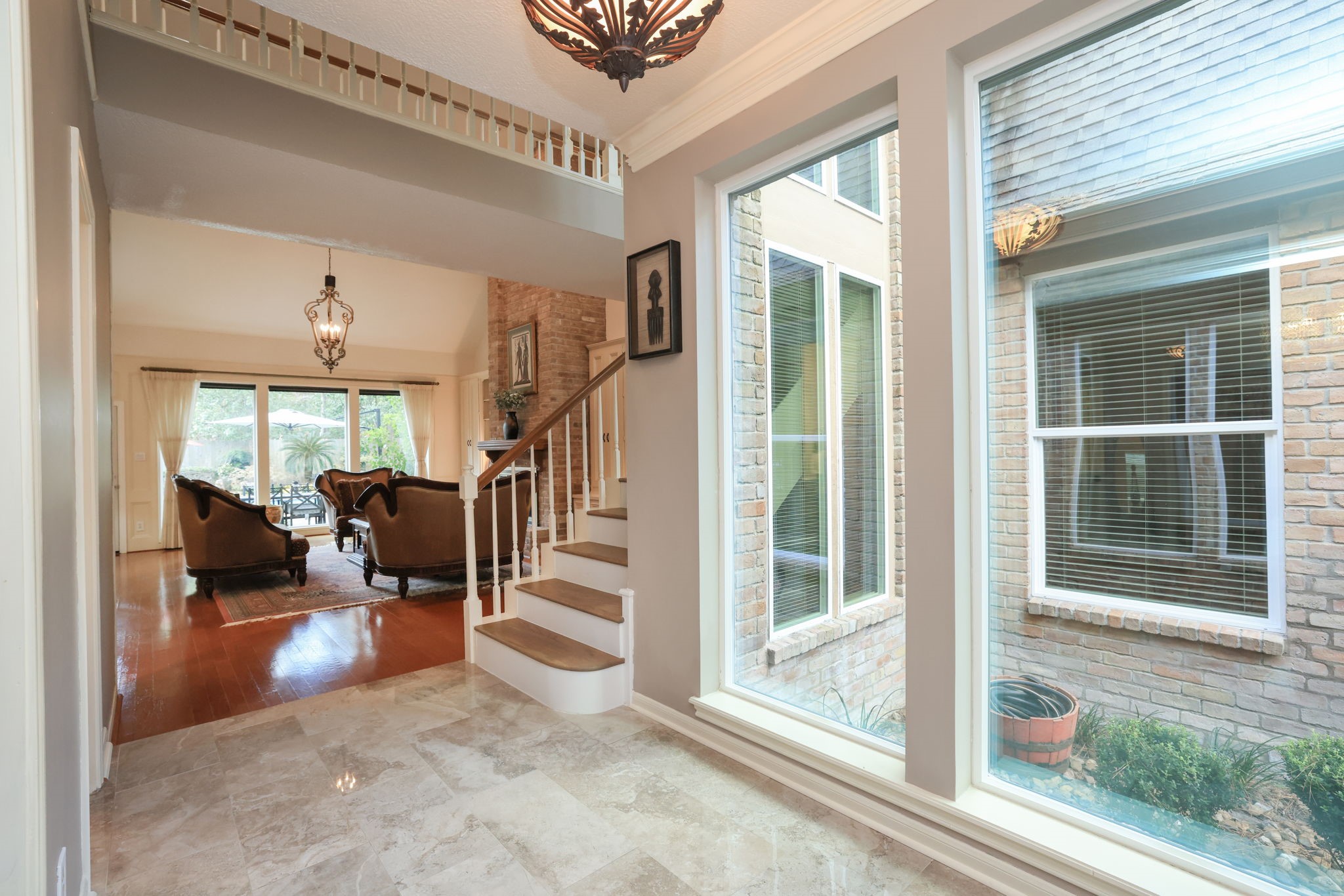 16123 Chasemore Drive Spring, TX 77379 - Photo 5 of 50 The bright and inviting entryway features floor to ceiling large windows, elegant lighting fixtures, and a view into the open living area.