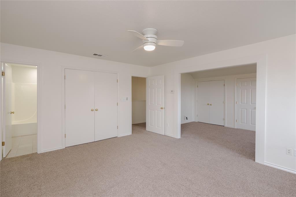 364 Parker Road, Unit A Van Alstyne, TX 75495 - Photo 31 of 39 Second primary bedroom.Carpeted room featuring a ceiling fan with integrated lighting, multiple white panel doors, and neutral wall tones