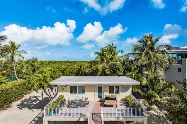 a view of a white house with a yard