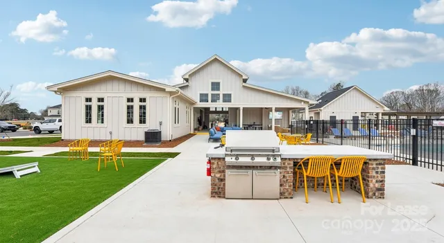 a view of house with swimming pool and chairs