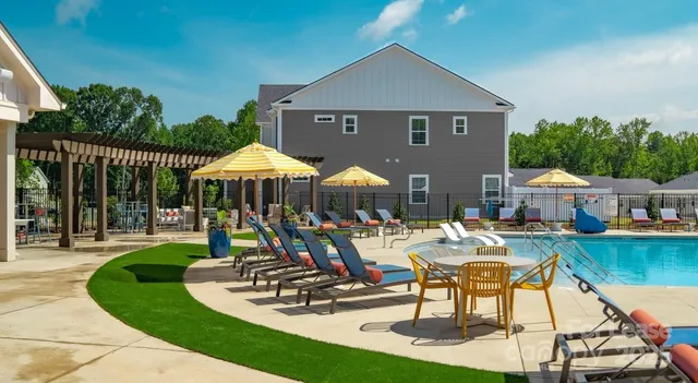 a view of a house with backyard water fountain and sitting area